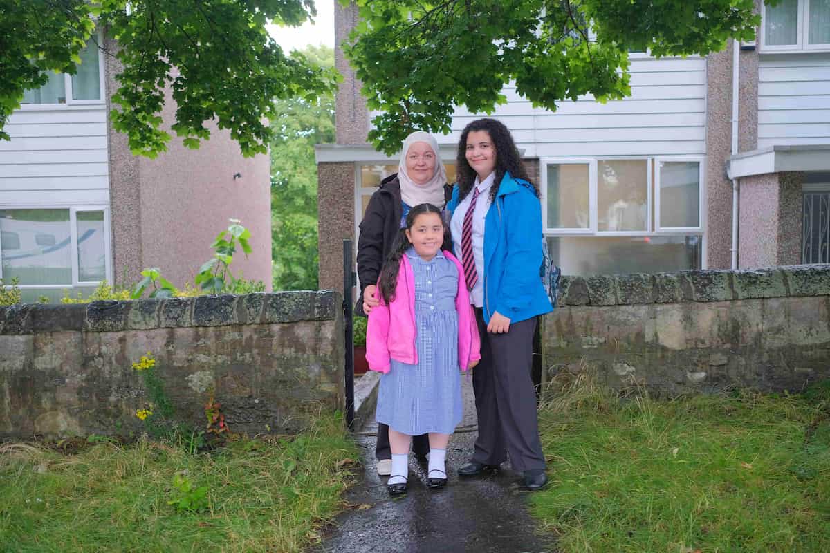 Photo of mother and children walking to school 