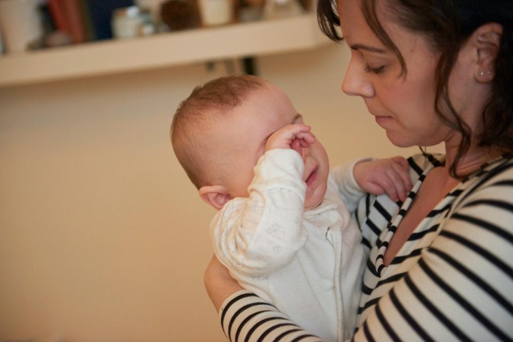 photo of baby cuddling mum