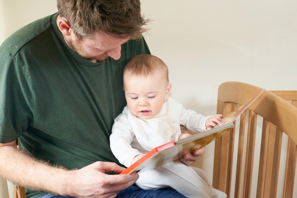 photo of baby reading with dad