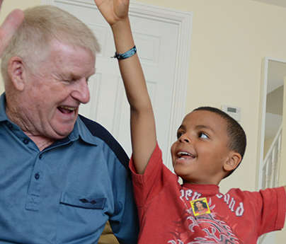 Photo of a child and his grandfather playing 