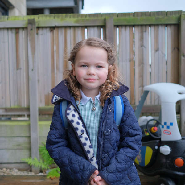 Photo of a young girl standing out side in coat 