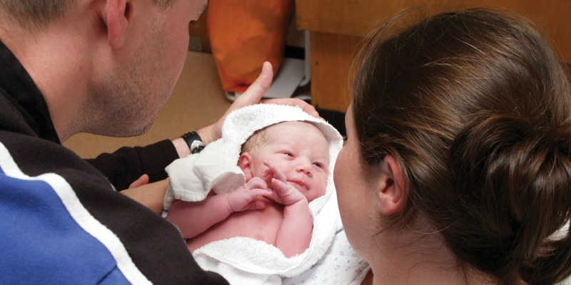 Photo of a couple holding their newborn baby