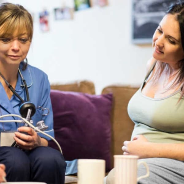 Photo of a nurse and a mother sitting together in a hospital