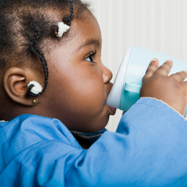 toddler drinking milk from a cup