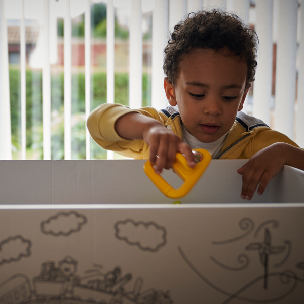 Image of a toddler putting a toy in a box.