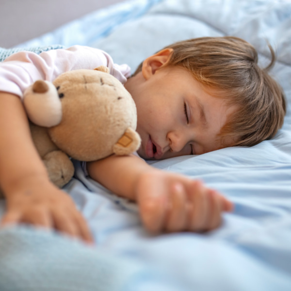 toddler in bed with teddy