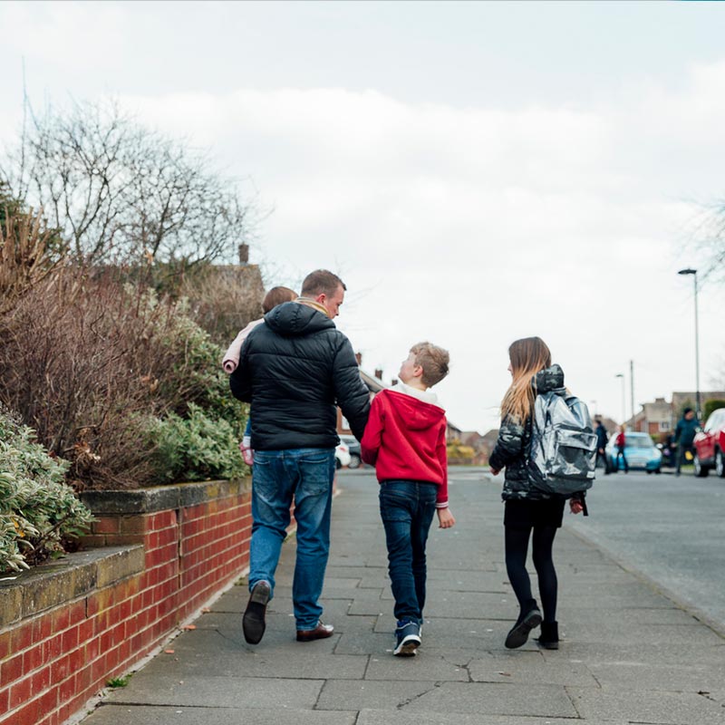 Dad and children walking home from school