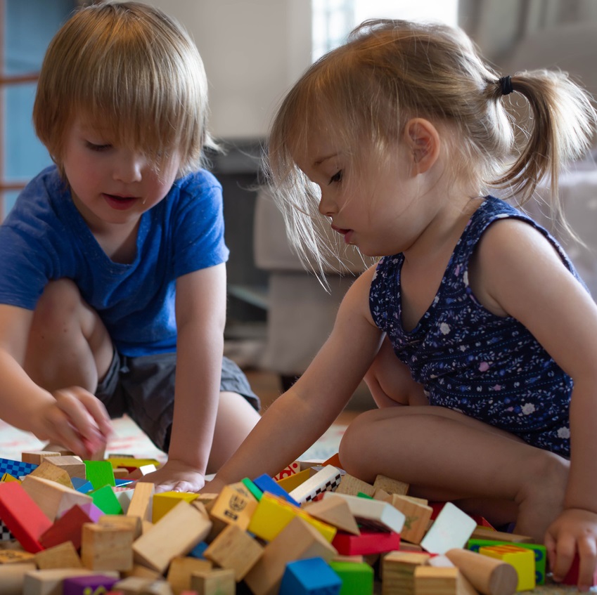 Toddlers playing together with blocks