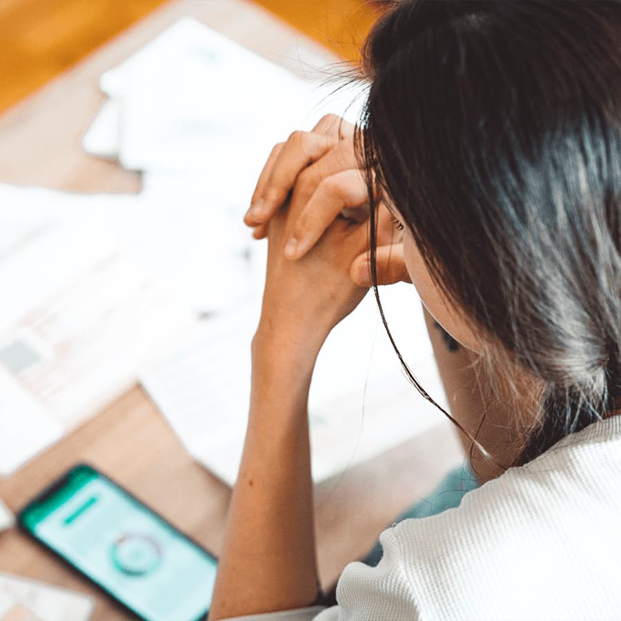 Woman looking at her mobile and filling in forms