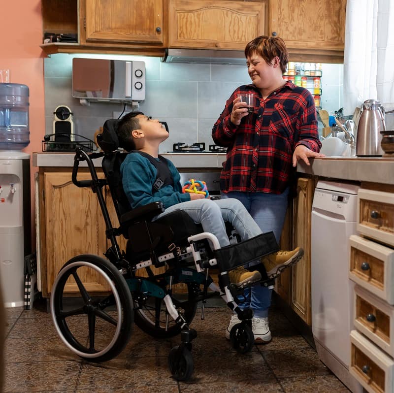 Mum and son talking in the kitchen, the boy is in a wheelchair
