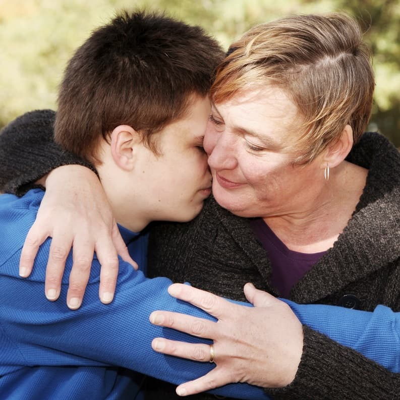 Mum hugging teenage son