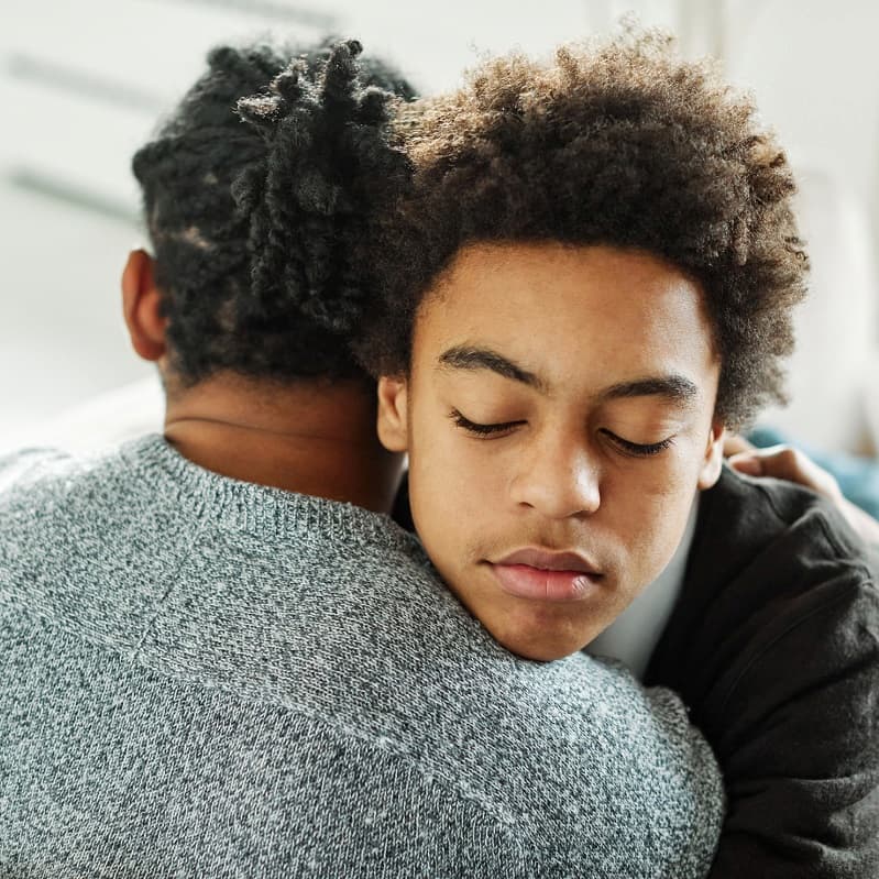 Teen boy hugging his father